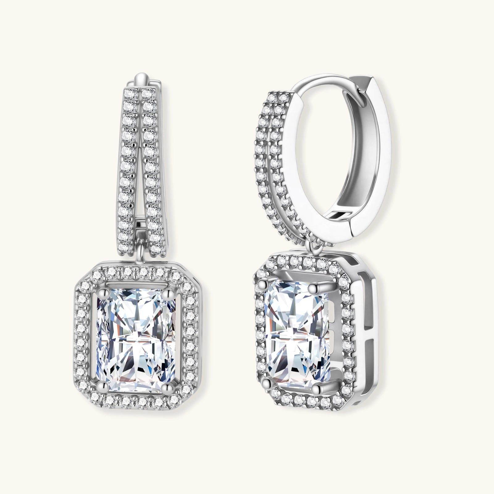 Sterling silver huggie hoops with emerald-cut moissanite drops featuring pavé-set crystals on white background.