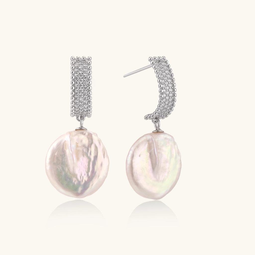 Rhodium-plated silver curved stud with pave stones and baroque pearl drop on white background