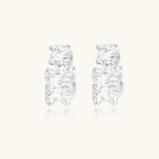 White gold plated sculptural hoop earrings with organic wavy edges and reflective metallic finish on cream background