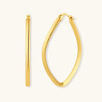 Set of geometric gold-plated sterling silver hoop earrings in oval and cushion shapes on cream background